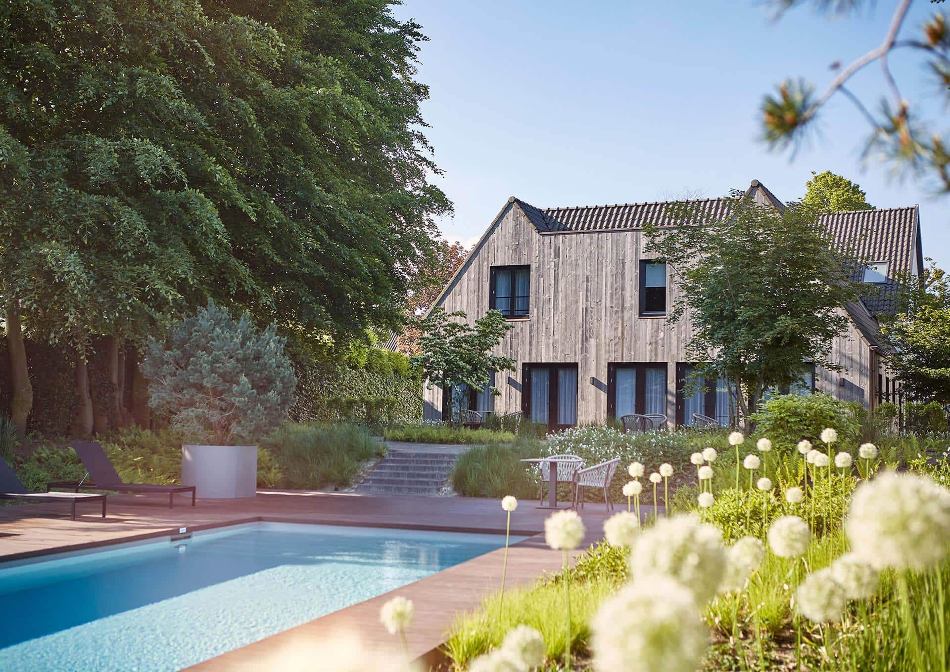 Luxury Bernardus Golf Resort accommodation with outdoor pool, modern wooden lodge, and lush garden